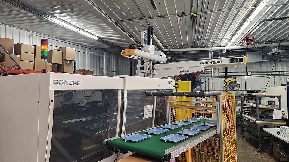 Injection moulding machine with a robot and conveyor